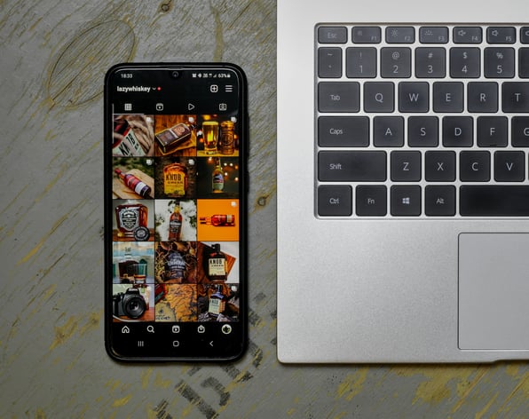 A phone with a social media app open next to a laptop 